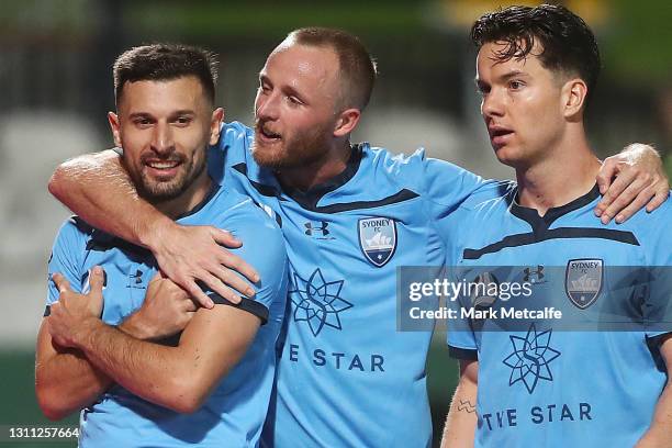 Kosta Barbarouses of Sydney FC celebrates scoring a goal with team mates Rhyan Grant and Alexander Baumjohann during the A-League match between...