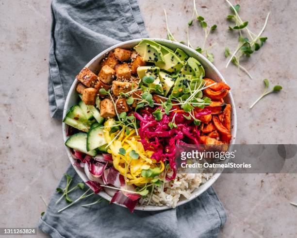 buddha bowl with pan roasted tofu, avocado, sweet potato, rice, vegetables and mixed seeds - bowl photos et images de collection