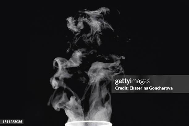 beautiful white abstract steam from tea or coffee on a black isolated background. - humo fotografías e imágenes de stock