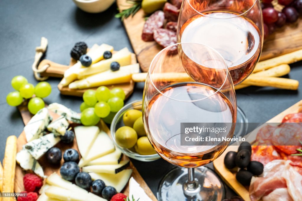 Two glasses of rose wine with cheese and salami, olives
