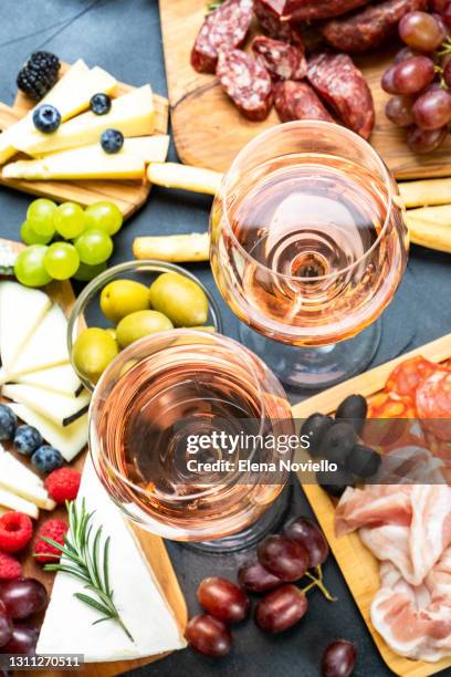 two glasses of rose wine with cheese and salami, olives - aperitif stock-fotos und bilder