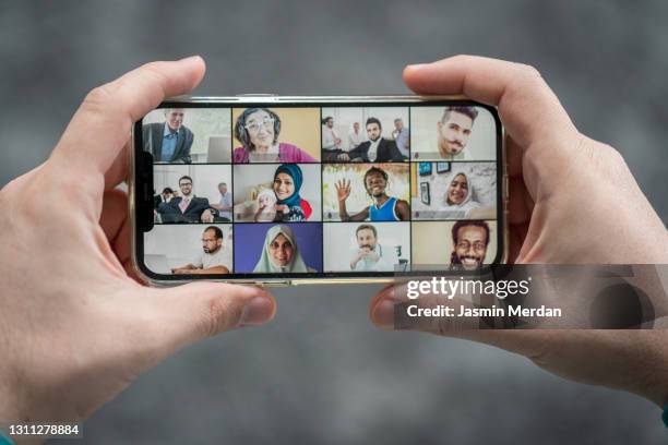 holding smartphone in hands with online video conference - horizontal - fotografias e filmes do acervo