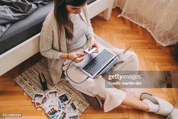 donna che stampa foto dal suo laptop - computer cable foto e immagini stock