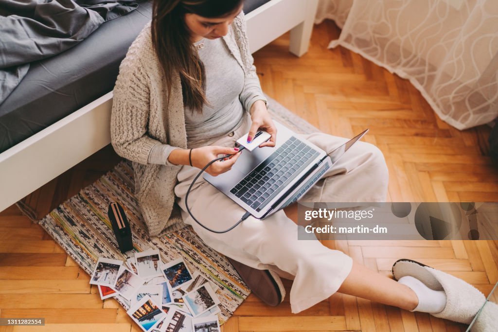 Vrouw die foto's van haar laptop afdrukt