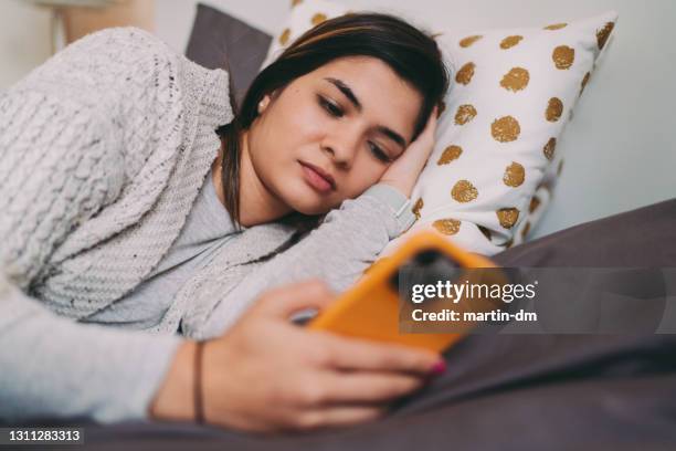 vrouw in bed dat op telefoon sms't - girl in her bed stockfoto's en -beelden