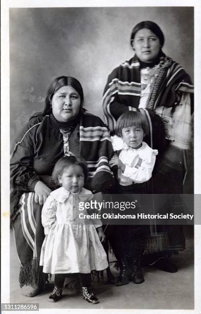 Postcard features a photograph of a pair of unidentified women and children of the Osage Nation, Pawhuska, Oklahoma Territory, circa 1918