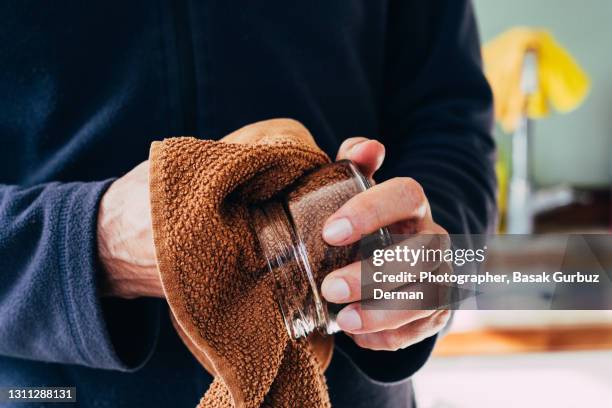 a man wiping washed dishes with towel - tea towels stock pictures, royalty-free photos & images