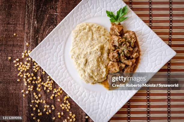 polenta taragna with stew and porcini mushrooms, italy - polenta fotografías e imágenes de stock