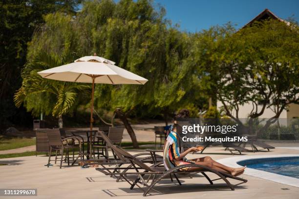 touristisches sonnenbaden im sommerhaus - gartenschirm stock-fotos und bilder