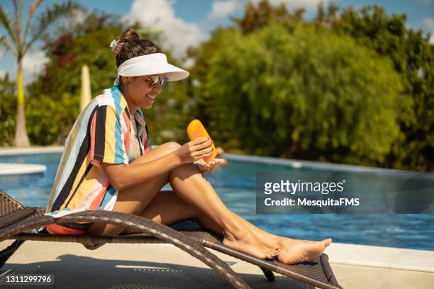 プールで日光浴をする女性 - サンバイザー ストックフォトと画像