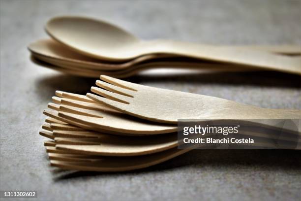 wooden spoons and forks in a table - eetgerei stockfoto's en -beelden