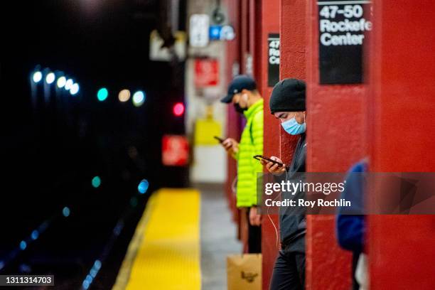 Commuters wear masks as she waits for the F train at the 47-50 Sts - Rockefeller Ctr subway station on April 06, 2021 in New York City. After...