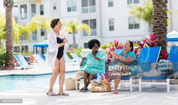 three senior women vacationing, dancing on pool deck - chubby swimsuit stock pictures, royalty-free photos & images