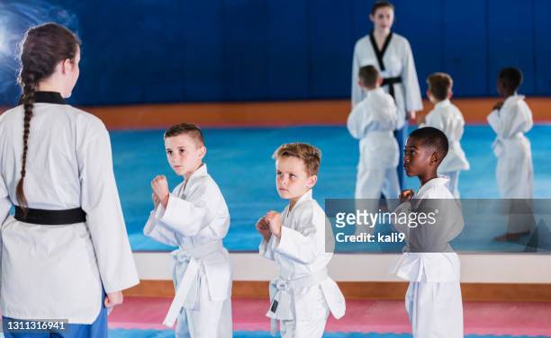 three boys in taekwondo class with instructor - karateka stock pictures, royalty-free photos & images