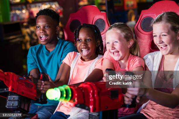 quatre enfants jouant le jeu d’arcade d’amusement - arcade photos et images de collection