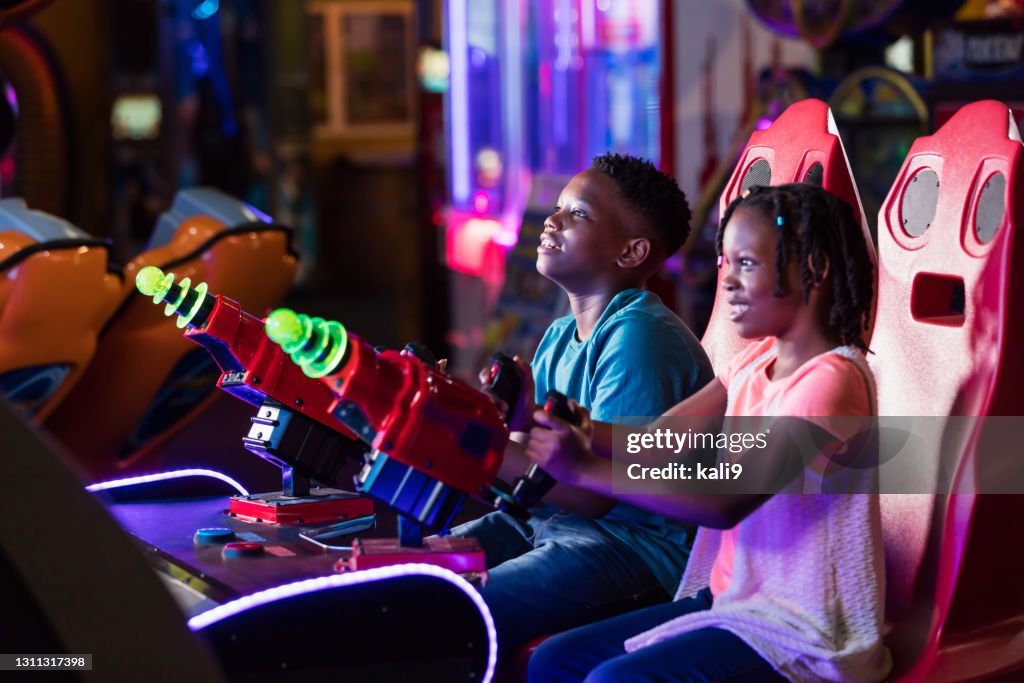 Niño y hermana jugando juego arcade de diversión