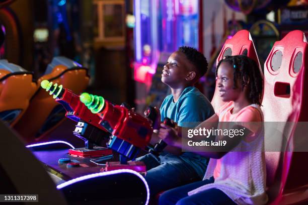 boy and sister playing amusement arcade game - arcade stock pictures, royalty-free photos & images