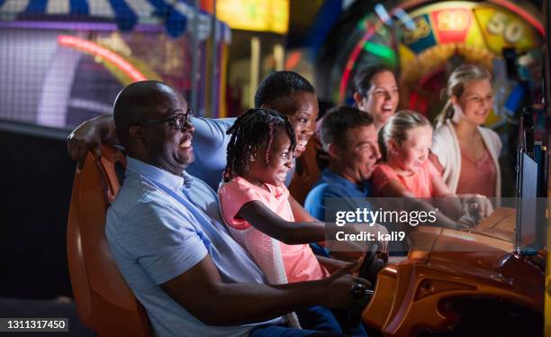 duas famílias jogando um jogo de fliperama - amusement arcade - fotografias e filmes do acervo