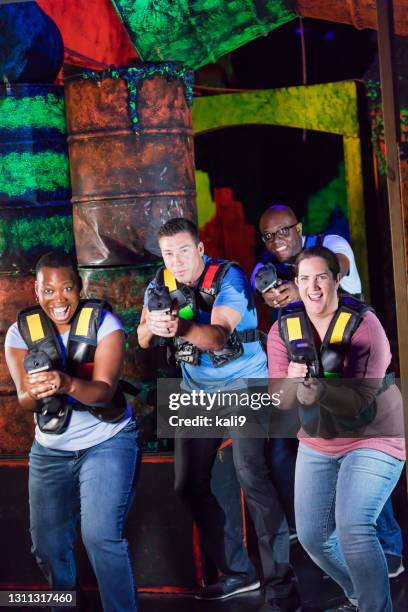 quattro adulti multietnici che giocano al laser tag - acchiappino foto e immagini stock