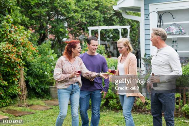 family with two adult children in back yard, drinking - man holding out flowers stock pictures, royalty-free photos & images