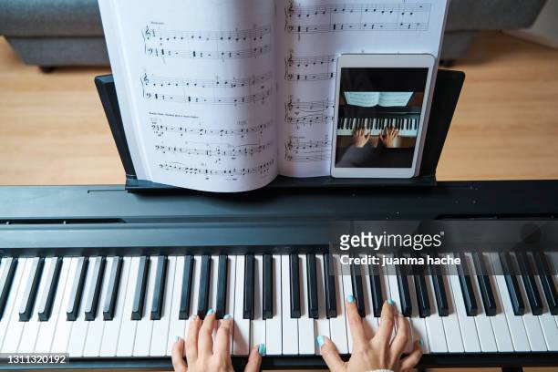 close-up of a woman having online piano lessons at home. - tasteninstrument stock-fotos und bilder