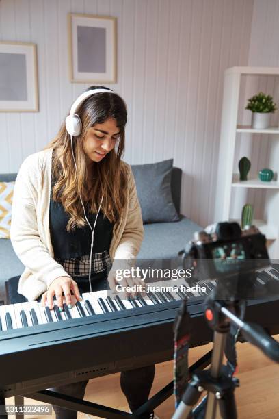 woman making a video with a camera while playing the piano at home. - sintetizador imagens e fotografias de stock