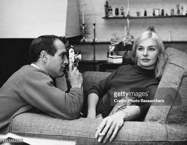 View of married American actors Paul Newman and Joanne Woodward, the former of whom photographs the latter, in their Greenwich Village apartment, New...