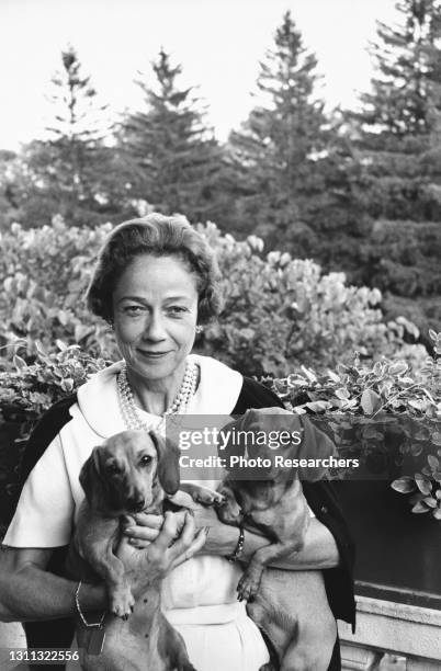 Portrait of American socialite and philanthropist Brooke Astor as she poses with pet dachshunds, circa 1960s.