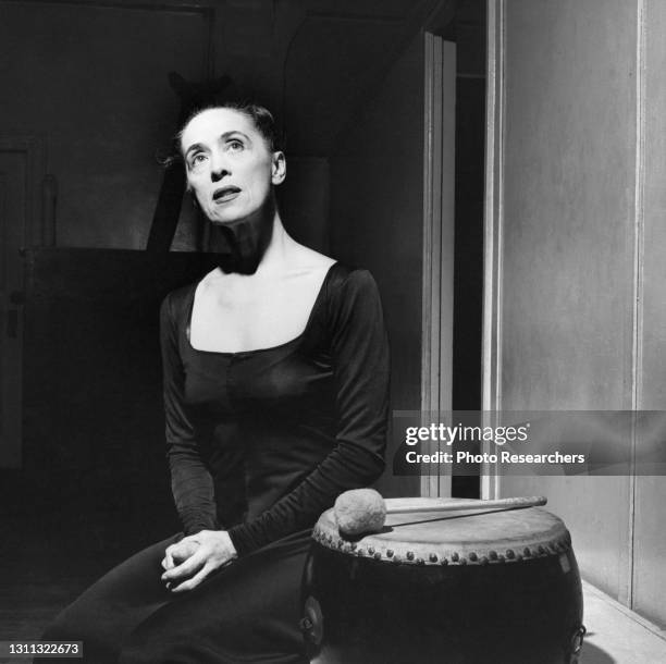 Portrait of American dancer and choreographer Martha Graham as she sits beside a drum, circa 1960s.