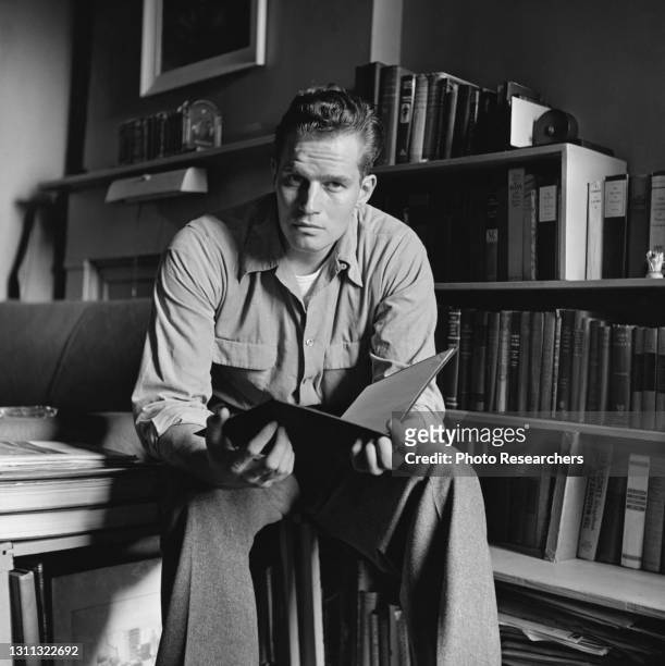 Portrait of American actor Charlton Heston as he sits in his apartment , New York, New York, 1950.
