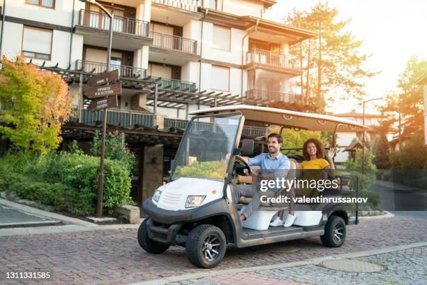 hotel employee ride tourist woman with luggage in golf cart to the hotel room - sports venue employee stock pictures, royalty-free photos & images