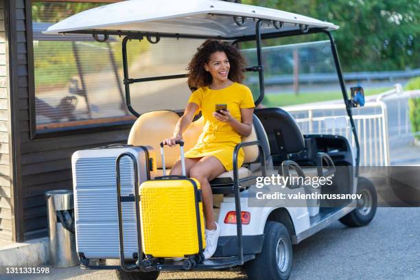 hotel employee ride tourist woman with luggage in golf cart to the hotel room - golf attendant stock pictures, royalty-free photos & images