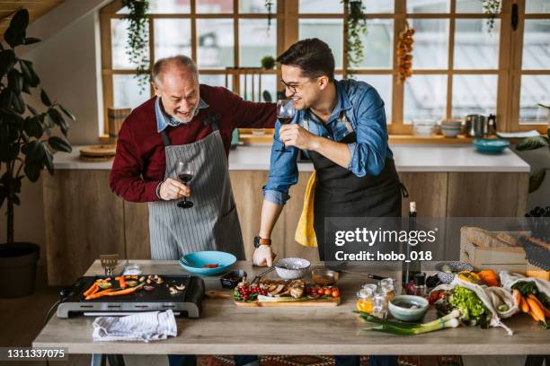 father teaching his son cooking tricks - fathers day lunch stock pictures, royalty-free photos & images