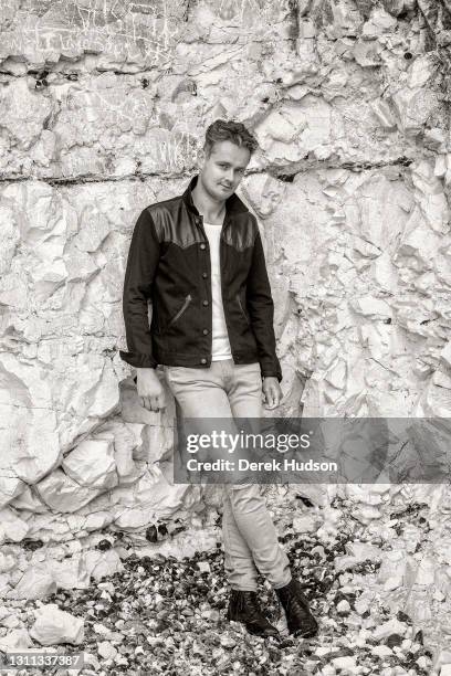 English pop singer and musician Tom Chaplin pictured on the pebble beach at Birling Gap, near the resort town of Eastbourne during a photo shoot to...