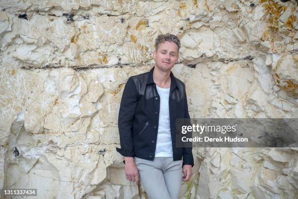 English pop singer and musician Tom Chaplin pictured on the pebble beach at Birling Gap, near the resort town of Eastbourne during a photo shoot to...