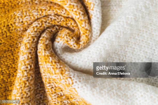 texture of knitted sweater folded in a swirling pattern with color gradient: from white to bright yellow. flat lay style, close-up. - sweater weather stock pictures, royalty-free photos & images