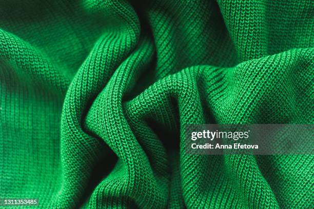 texture of knitted green sweater folded in a swirling pattern. flat lay style, close-up. - polyester fotografías e imágenes de stock