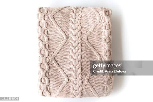texture of folded knitted beige sweater with pattern on white background. flat lay style, close-up. - cozy blankets folded stock pictures, royalty-free photos & images
