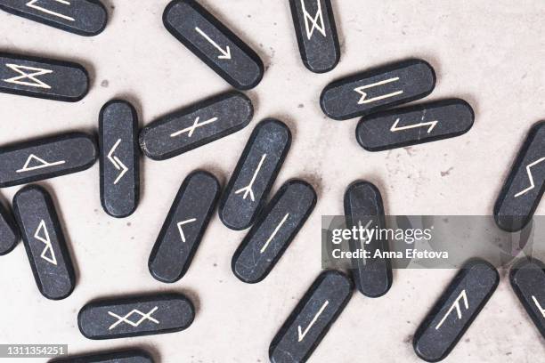 stone runes on concrete gray background. concept of magic esoteric rituals. trendy colors of the year 2021. top table view and extreme close-up - rune symbols stock pictures, royalty-free photos & images