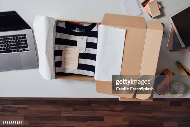 vue ci-dessus d’une boîte ouverte avec des vêtements préparés pour être envoyés - wrapping paper stock photos et images de collection