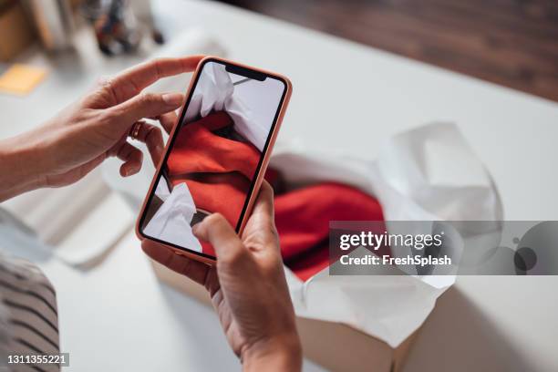 anónimo propietario de una pequeña tienda de ropa y zapatos en línea tomando fotos de la mercancía antes del envío - fotostock fotografías e imágenes de stock