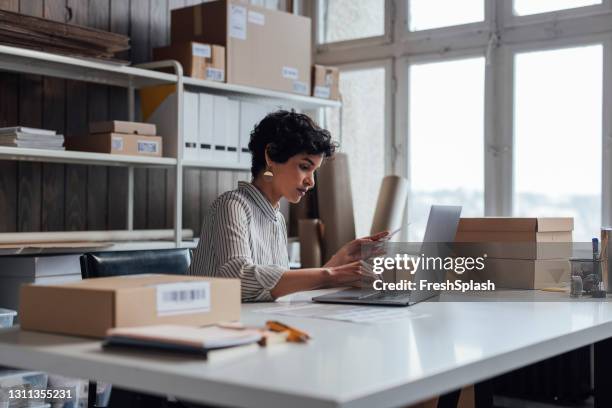 beautiful online store owner working on her laptop - vendor management stock pictures, royalty-free photos & images