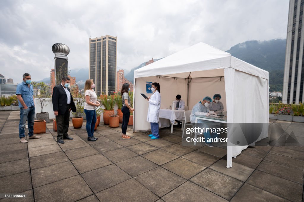 Personas en la fila a la espera de recibir su vacuna COVID-19 en un stand