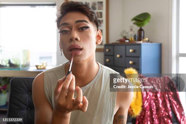 man applying drag queen makeup at home - trucco per il viso foto e immagini stock