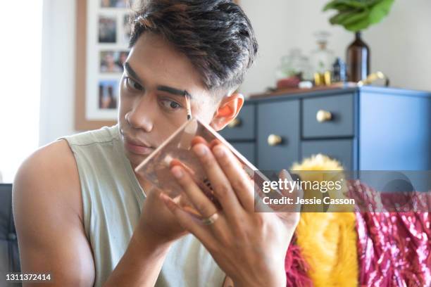 man applying drag queen makeup at home - eyebrow pencil fotografías e imágenes de stock