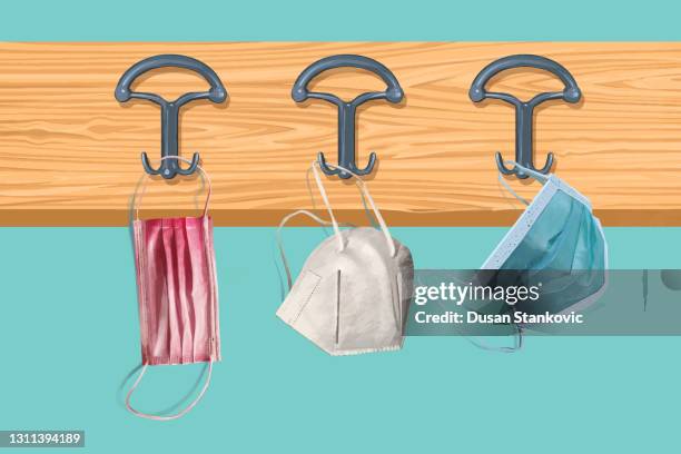 face protective masks hanging on a coat rack - coat stand stock illustrations