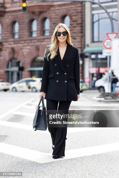 German actress Lara-Isabelle Rentinck wearing a black suit with gold buttons by Zara, a black bag with gold details by Ralph Lauren, black sunglasses...