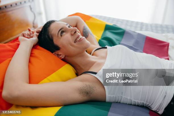 young woman relaxing on the bed - female hairy arms stock pictures, royalty-free photos & images