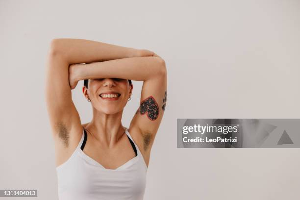 retrato de una joven que muestra el pelo de la axila - mujer peluda fotografías e imágenes de stock