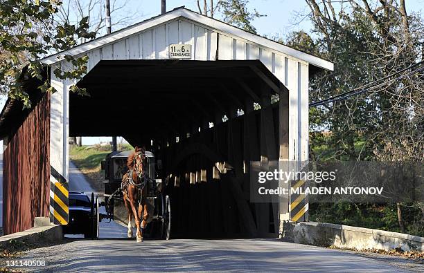 An Amish buggy passes exits the covered bridge on a road near Paradise, PA, November 01, 2011. The Amish people are known for their simple way of...